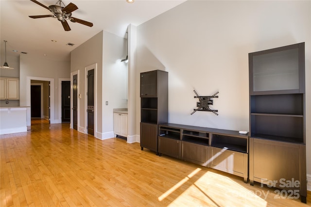 unfurnished living room featuring a ceiling fan, visible vents, light wood-style floors, and baseboards