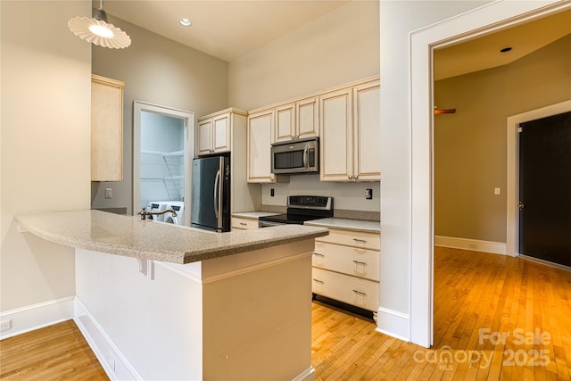 kitchen with light wood-style flooring, appliances with stainless steel finishes, baseboards, and a peninsula