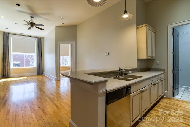 kitchen with dishwasher, open floor plan, light wood finished floors, and a sink