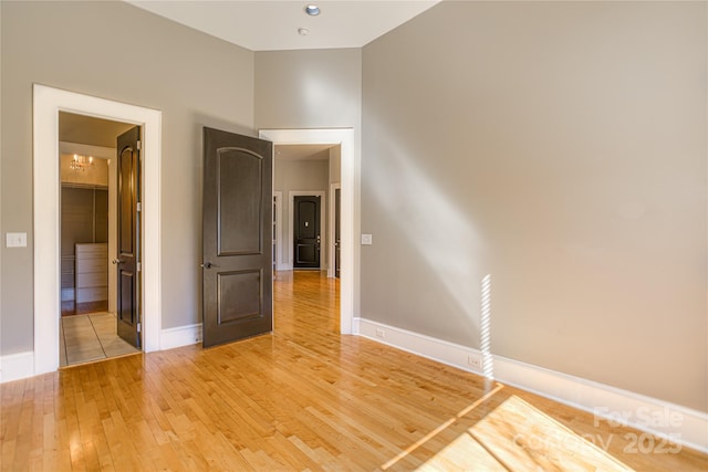 unfurnished room with baseboards and light wood-style flooring