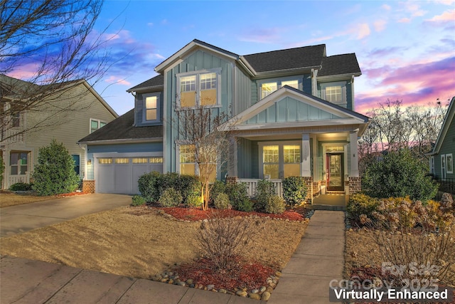 craftsman house with driveway, brick siding, board and batten siding, and a porch
