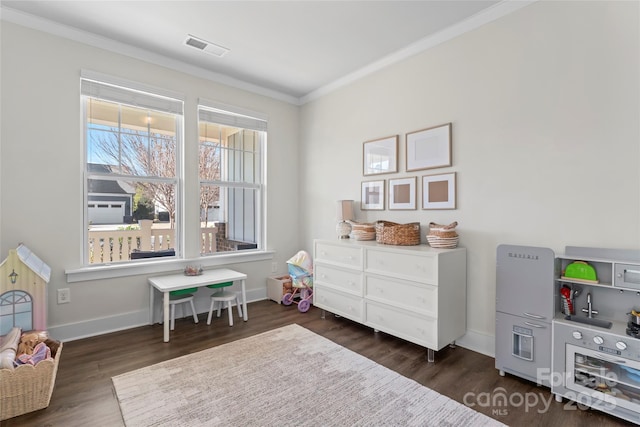 rec room with crown molding, visible vents, dark wood finished floors, and baseboards