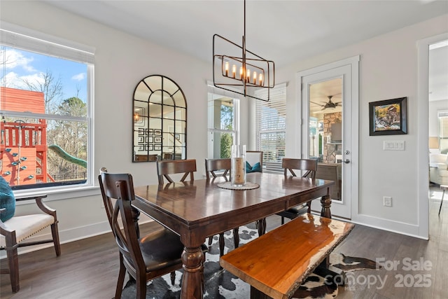 dining room featuring a notable chandelier, baseboards, and dark wood-type flooring