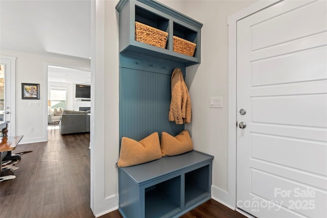 mudroom with dark wood finished floors and baseboards
