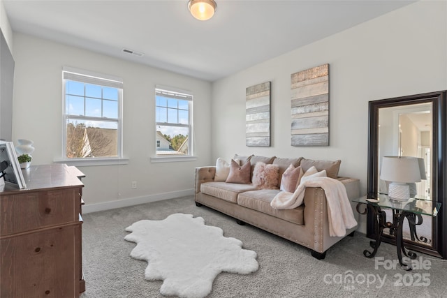 living area with light colored carpet, visible vents, and baseboards