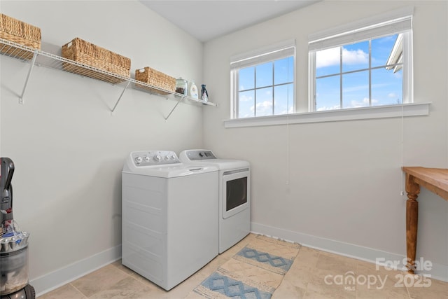 clothes washing area featuring washing machine and dryer, laundry area, light tile patterned flooring, and baseboards