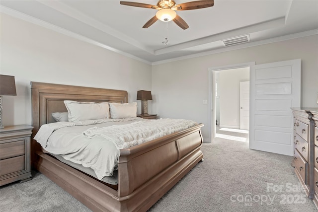 bedroom featuring light carpet, a raised ceiling, visible vents, and crown molding