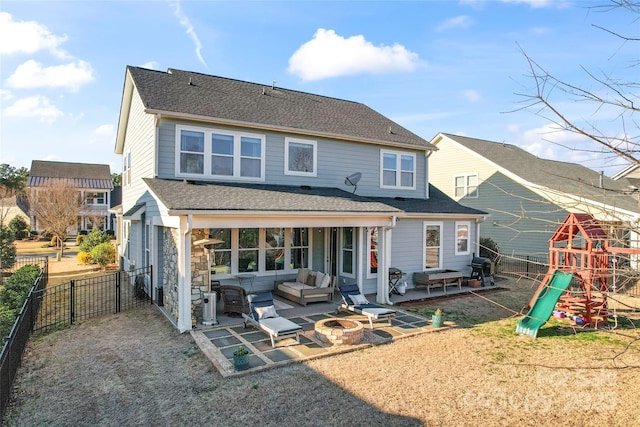 back of house featuring a shingled roof, an outdoor living space with a fire pit, a fenced backyard, a patio area, and a playground