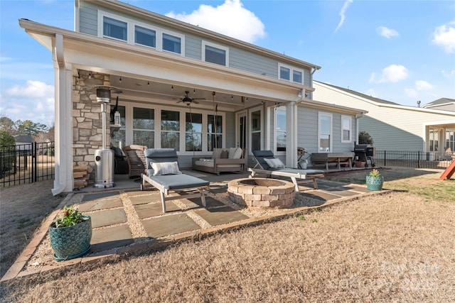 rear view of house with an outdoor living space with a fire pit, fence, a patio, and ceiling fan