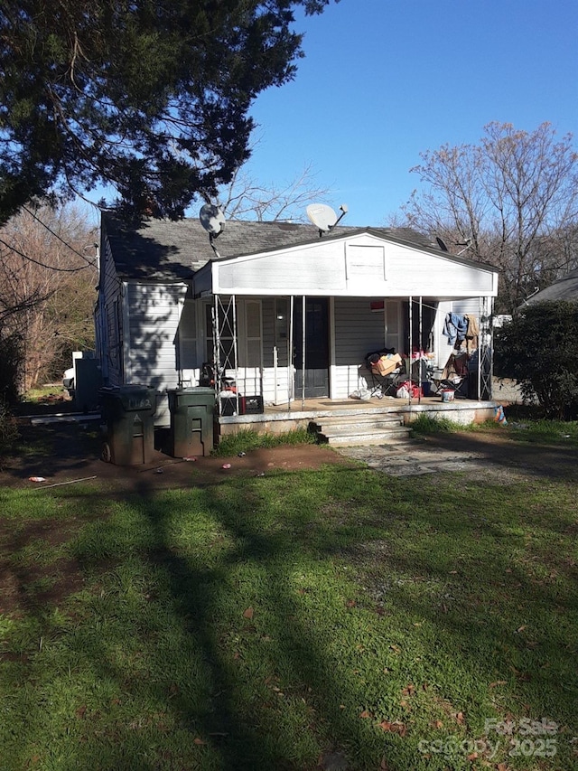 rear view of property featuring a lawn