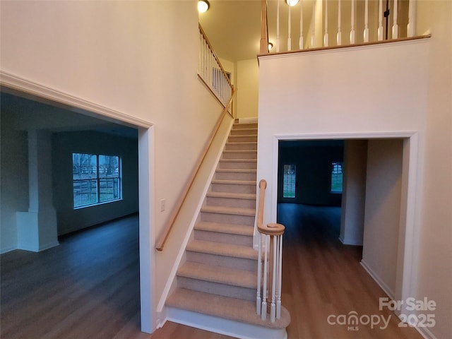 staircase featuring wood finished floors and baseboards