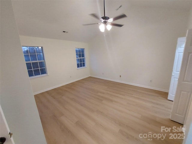 unfurnished bedroom with vaulted ceiling, visible vents, baseboards, and light wood finished floors