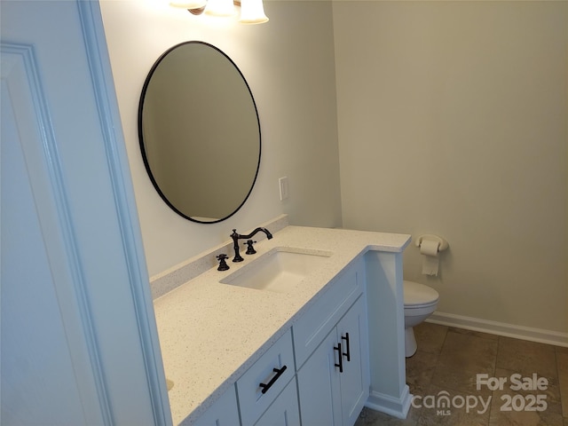 bathroom featuring vanity, toilet, baseboards, and tile patterned flooring