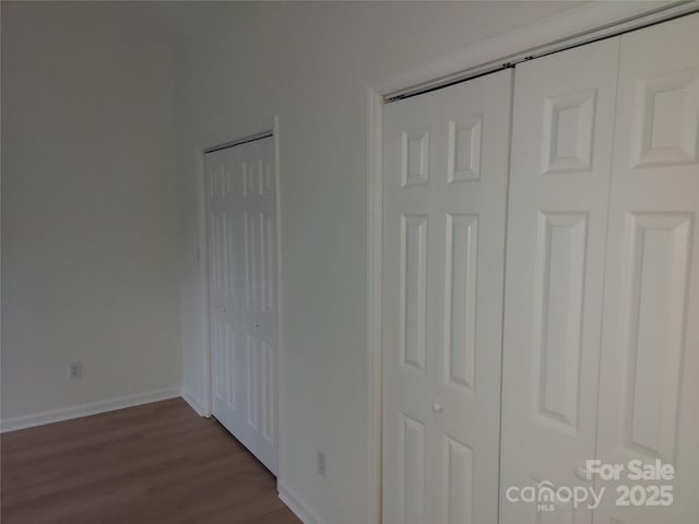 unfurnished bedroom with dark wood finished floors and baseboards