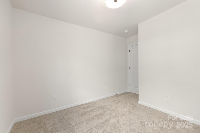 unfurnished room featuring baseboards and light colored carpet