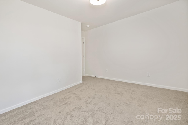 unfurnished room with light carpet and baseboards