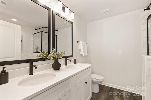 bathroom featuring visible vents, a sink, and wood finished floors