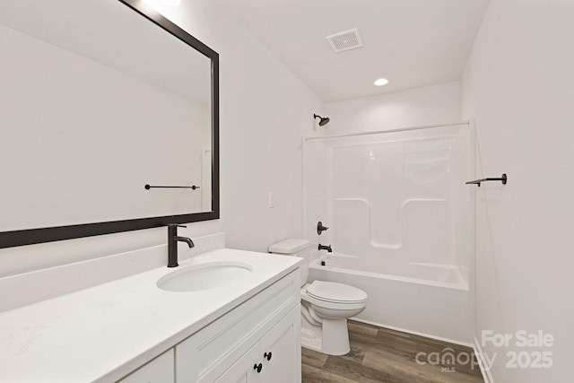 full bath with visible vents, bathing tub / shower combination, toilet, wood finished floors, and vanity