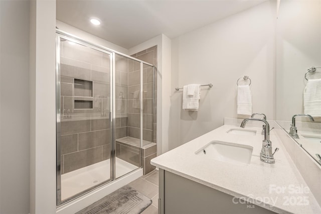 bathroom featuring double vanity, recessed lighting, a stall shower, tile patterned floors, and a sink