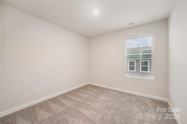 carpeted empty room featuring visible vents and baseboards