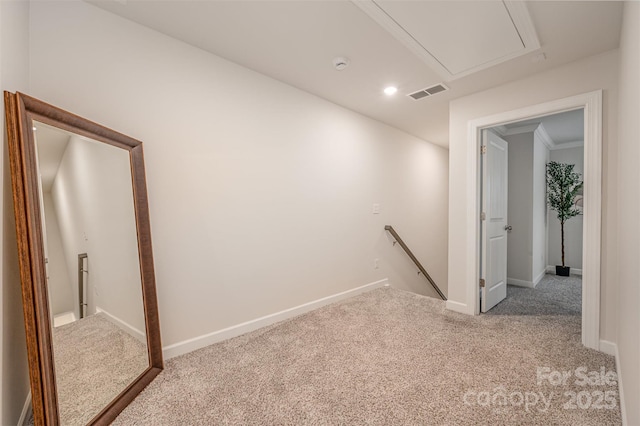 corridor featuring visible vents, baseboards, carpet, attic access, and an upstairs landing