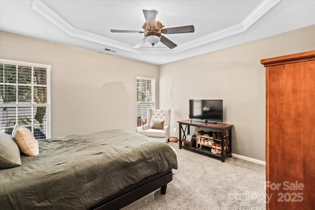 bedroom with a tray ceiling, ceiling fan, crown molding, and carpet