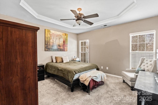 carpeted bedroom with multiple windows, crown molding, ceiling fan, and a raised ceiling