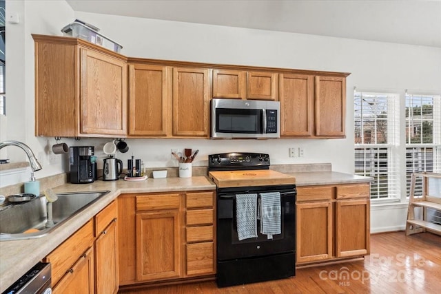 kitchen featuring appliances with stainless steel finishes, sink, and hardwood / wood-style flooring