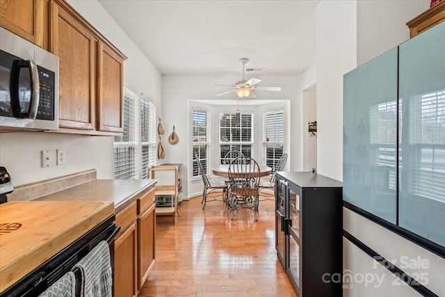 kitchen featuring ceiling fan, light hardwood / wood-style flooring, and stove