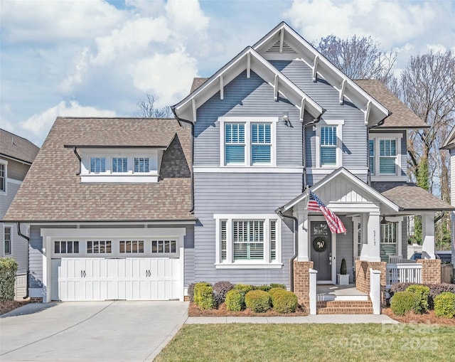 craftsman house with driveway, covered porch, an attached garage, and a shingled roof