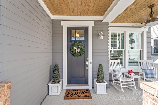 view of exterior entry featuring ceiling fan and a porch