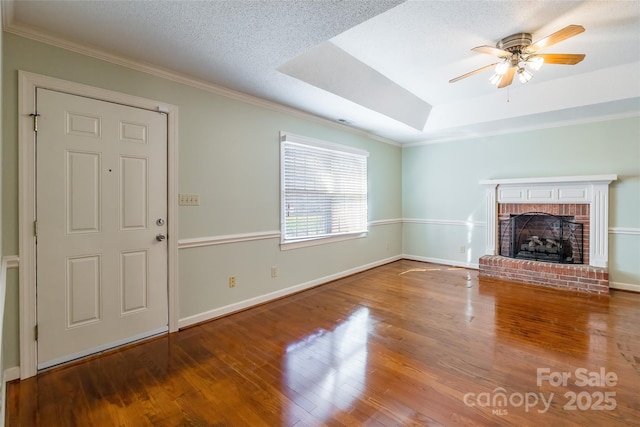 unfurnished living room featuring wood-type flooring, a textured ceiling, a brick fireplace, and ceiling fan