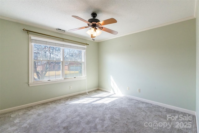 carpeted spare room featuring a textured ceiling, ornamental molding, and ceiling fan