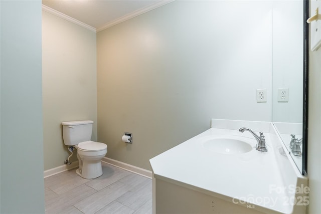 bathroom with hardwood / wood-style floors, ornamental molding, vanity, and toilet