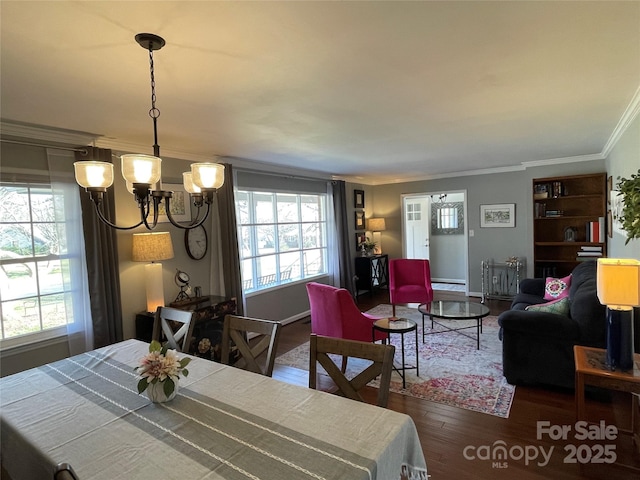 dining area featuring a notable chandelier, crown molding, and dark hardwood / wood-style floors