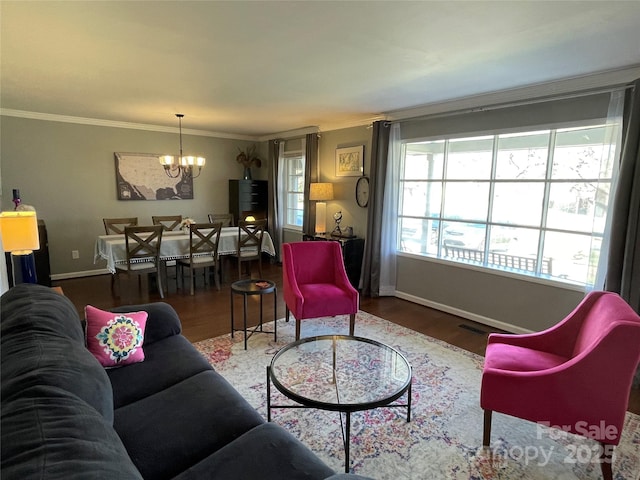 living room with ornamental molding, hardwood / wood-style floors, and a notable chandelier