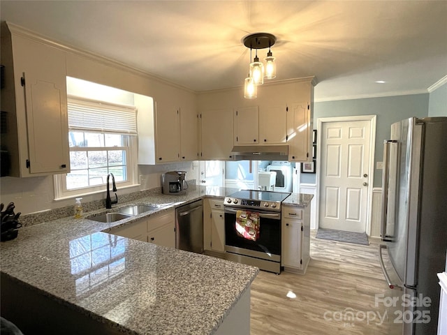 kitchen with kitchen peninsula, stainless steel appliances, sink, crown molding, and pendant lighting