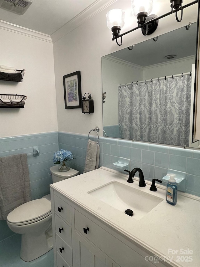 bathroom featuring tile walls, vanity, crown molding, and toilet