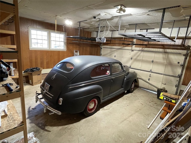 garage featuring a garage door opener and wood walls