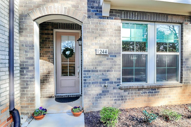 doorway to property with brick siding