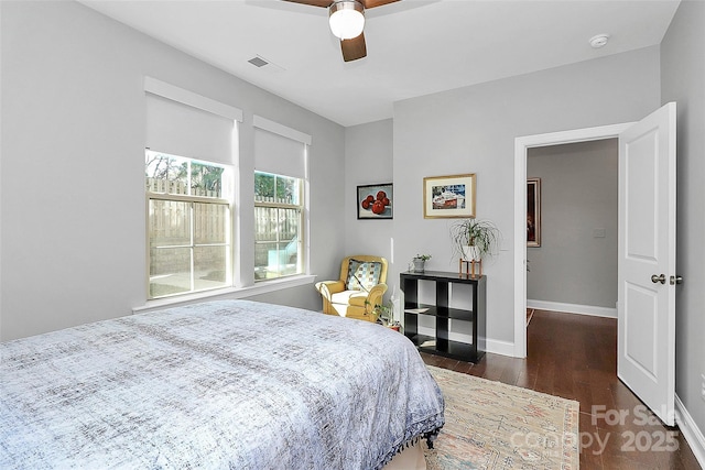 bedroom with baseboards, visible vents, dark wood-style flooring, and ceiling fan