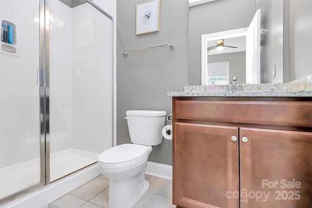 bathroom with baseboards, toilet, tile patterned floors, vanity, and a shower stall