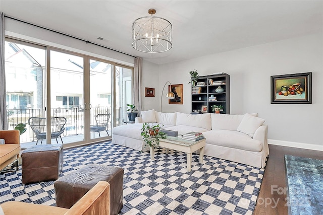 living room featuring dark wood-style floors, baseboards, a notable chandelier, and french doors