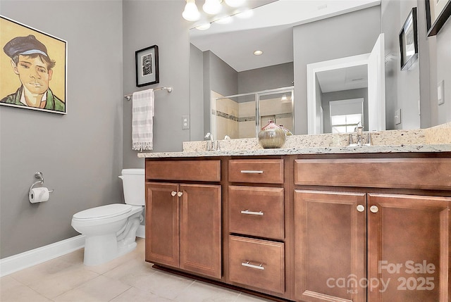 full bath with a sink, a stall shower, baseboards, toilet, and double vanity