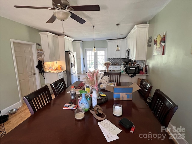 dining area featuring light wood-type flooring, a ceiling fan, and baseboards