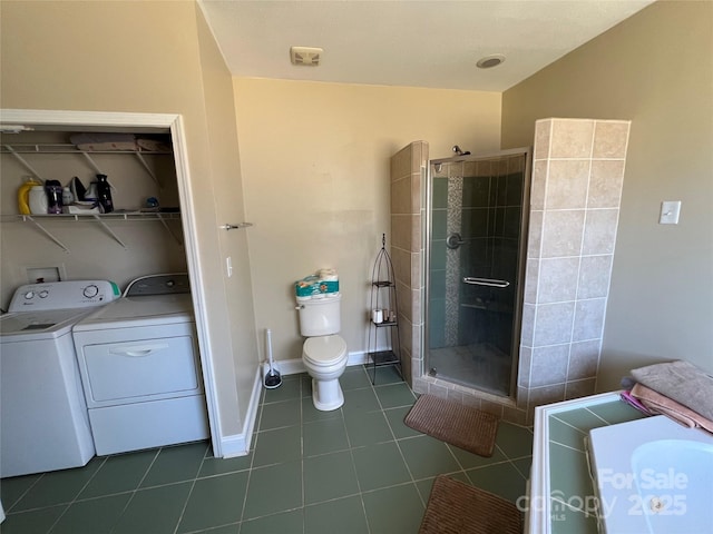 bathroom featuring washing machine and dryer, tile patterned flooring, a shower stall, and baseboards