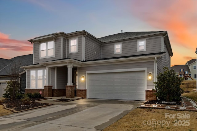 view of front of home featuring driveway, a garage, and brick siding