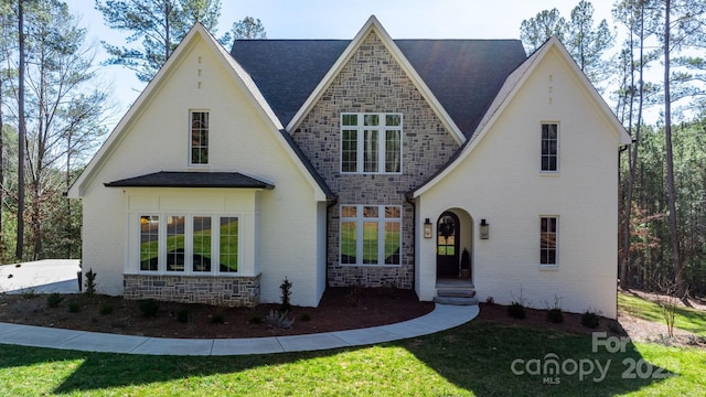 tudor-style house featuring stone siding and brick siding