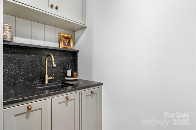 bar with backsplash, a sink, and wet bar