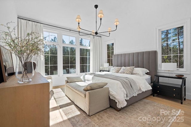 bedroom featuring light wood-type flooring and an inviting chandelier